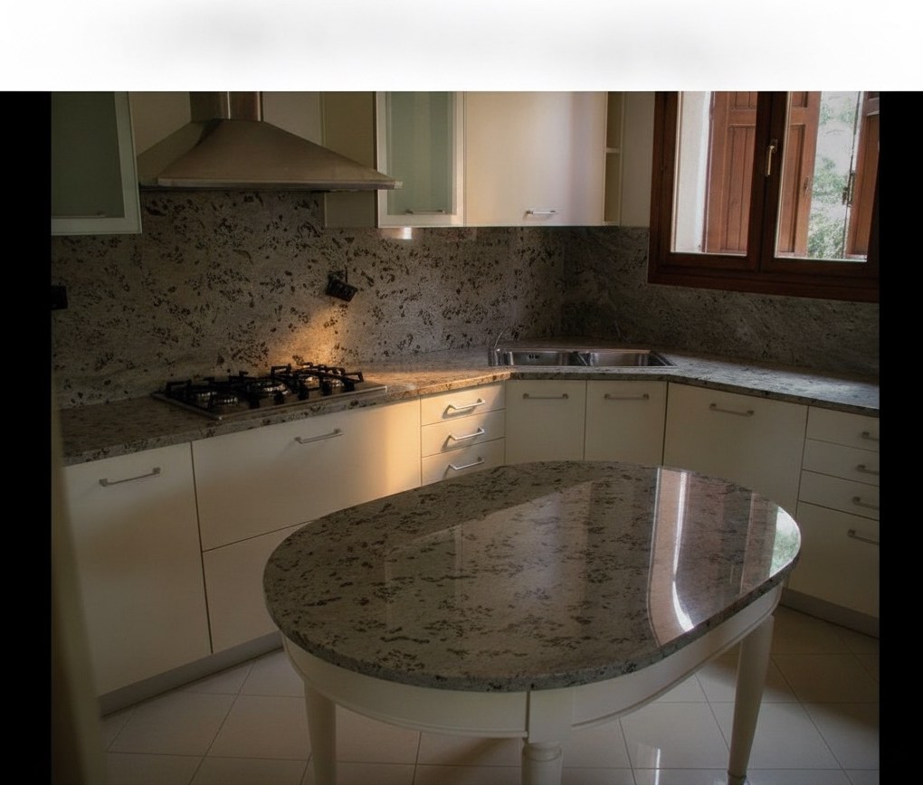 Cucina classica con basi bianche, piano e alzata in granito grigio, fuochi a gas, lavello in acciaio e isola ovale