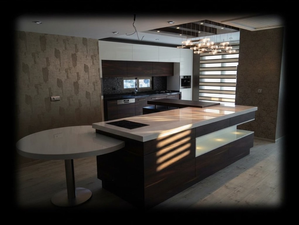 Cucina in legno scuro con piano in quarzo bianco, isola con piano a induzione e tavolo rotondo agganciato