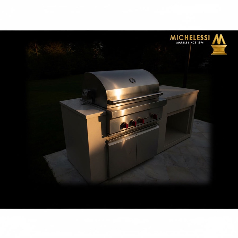 Barbecue a gas in acciaio incassato su pianale a isola bianco, in giardino su prato verde