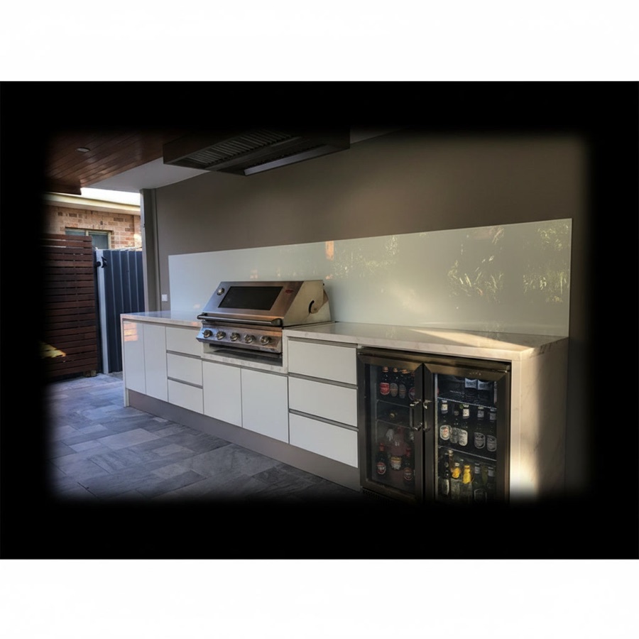 Cucina da esterno in gres bianco con frigo a doppia anta in vetro, barbecue da incasso e schienale chiaro