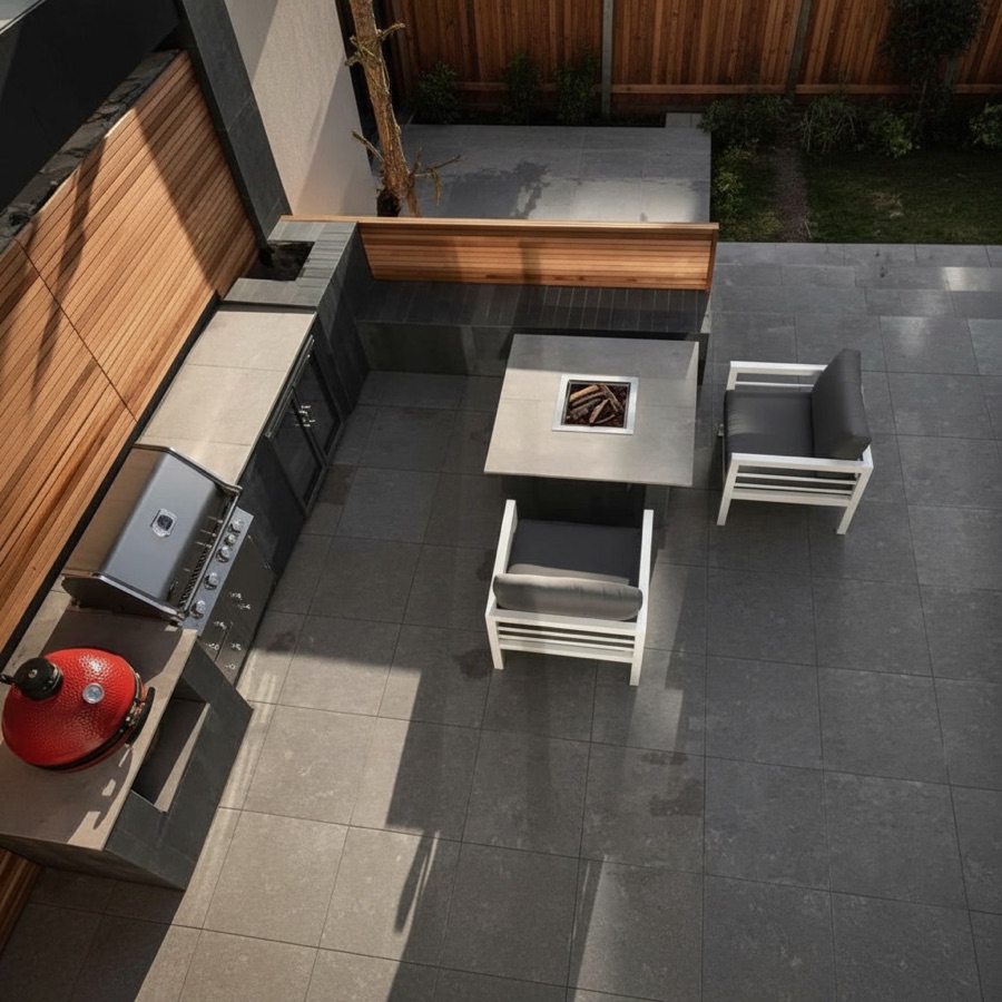 Cucina da esterno economica ad angolo con barbecue a gas, piano di appoggio, griglia rossa e tavolo con braciere