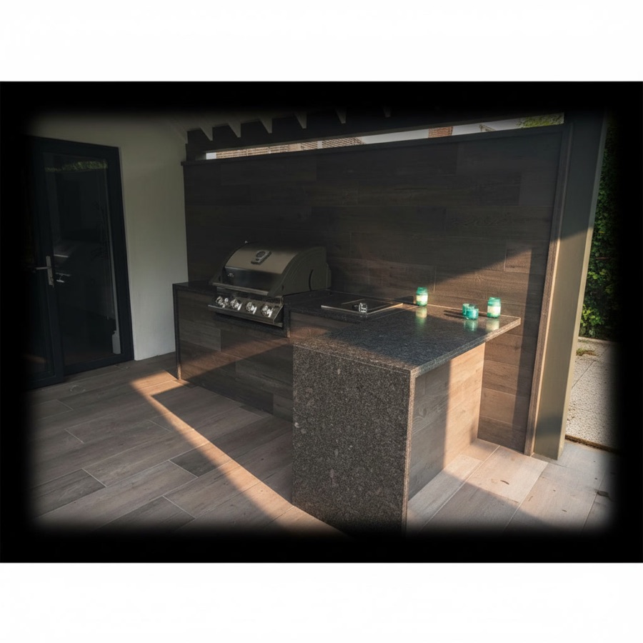 Cucina da esterno con piano in granito lucido a due livelli e barbecue professionale da incasso, parete in legno grigio