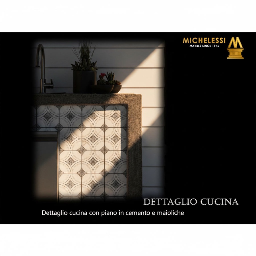 Dettaglio di cucina da esterno con piano in pietra refrattaria e fronte decorato in maioliche, piante grasse e rubinetto