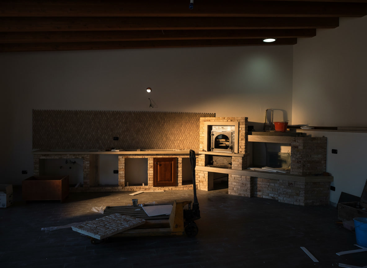 Cucina in muratura in costruzione con parete in pietra, camino e soffitto con travi in legno