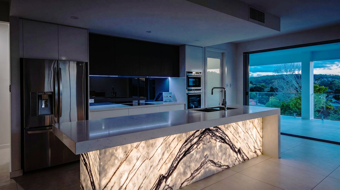 Visione di progetto: cucina ultramoderna con piano in quarzo bianco e isola con base in onice retroilluminato — cucine Michelessi
