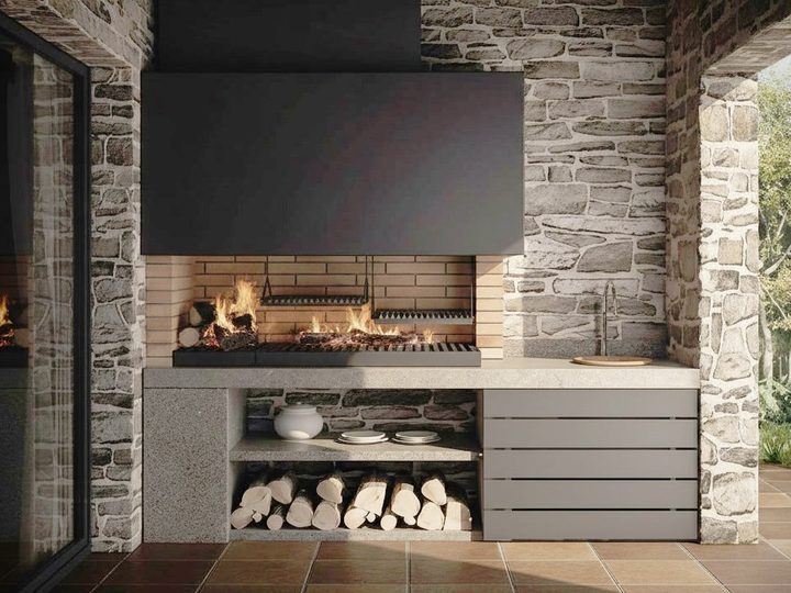 Grande barbecue moderno a legna con doppia griglia, cappa metallica nera, pareti in pietra e vano portalegna