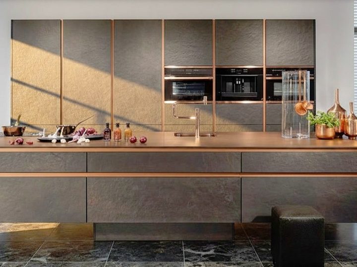 Indoor kitchen in dark wood with copper profiles, oven and integrated sink