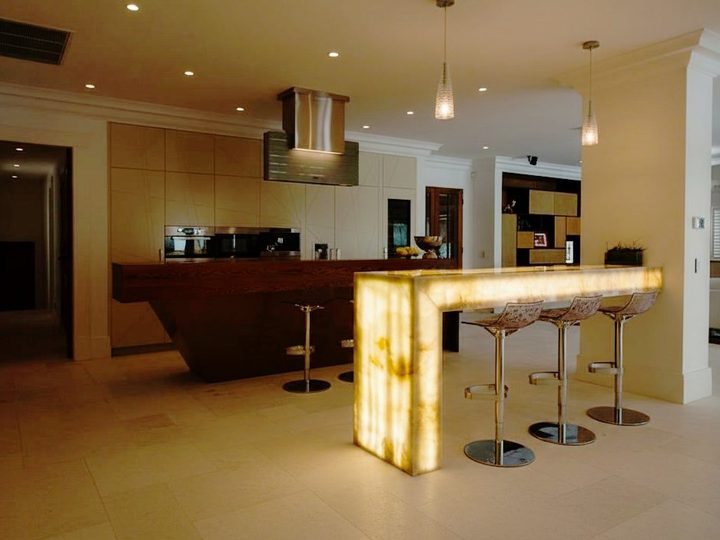 Solid wood kitchen with backlit marble L-shaped table and swivel stools