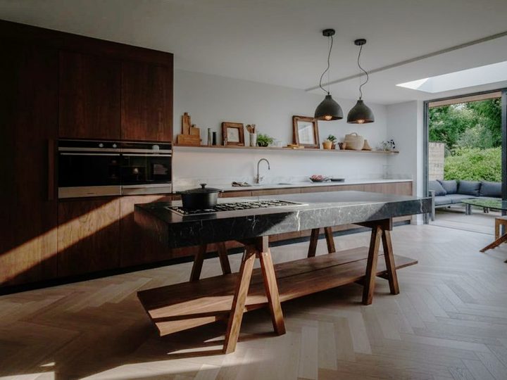 Wooden kitchen clad in porcelain stoneware with worktop on wooden trestles and bench