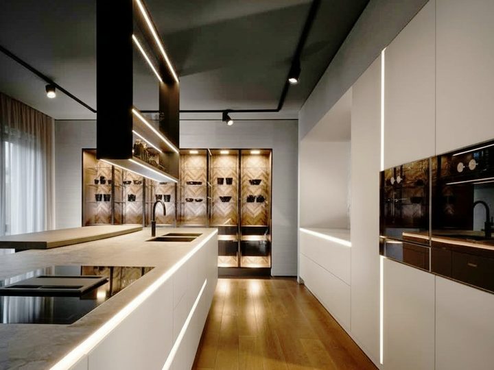 Cucina in legno laccato crema con piano in gres porcellanato, luci led e nicchie espositive