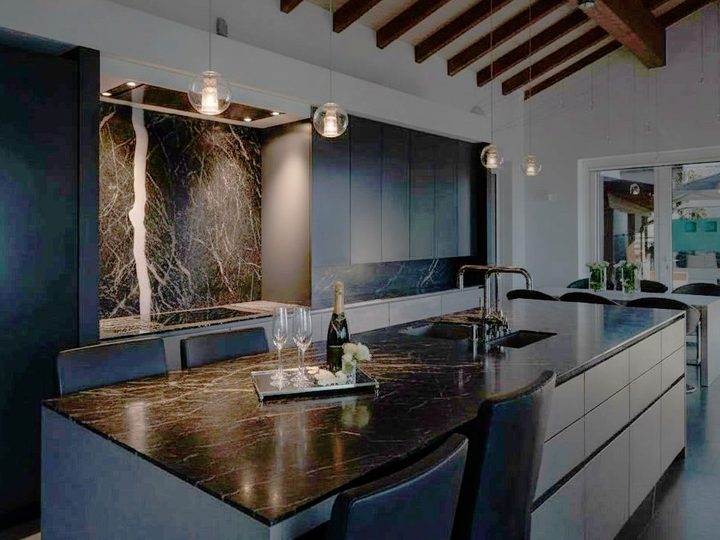 Elegant kitchen with black Marquina marble island, wenge wood cabinets and soft lighting