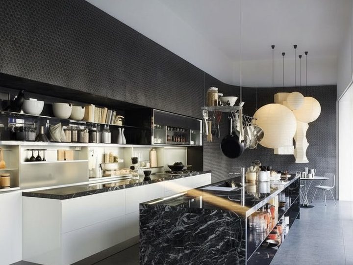 Integrated kitchen on black majolica tiled wall with black Marquina marble island