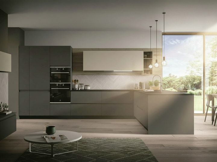 Modern dark grey kitchen with peninsula, cream wall units and wide window onto greenery