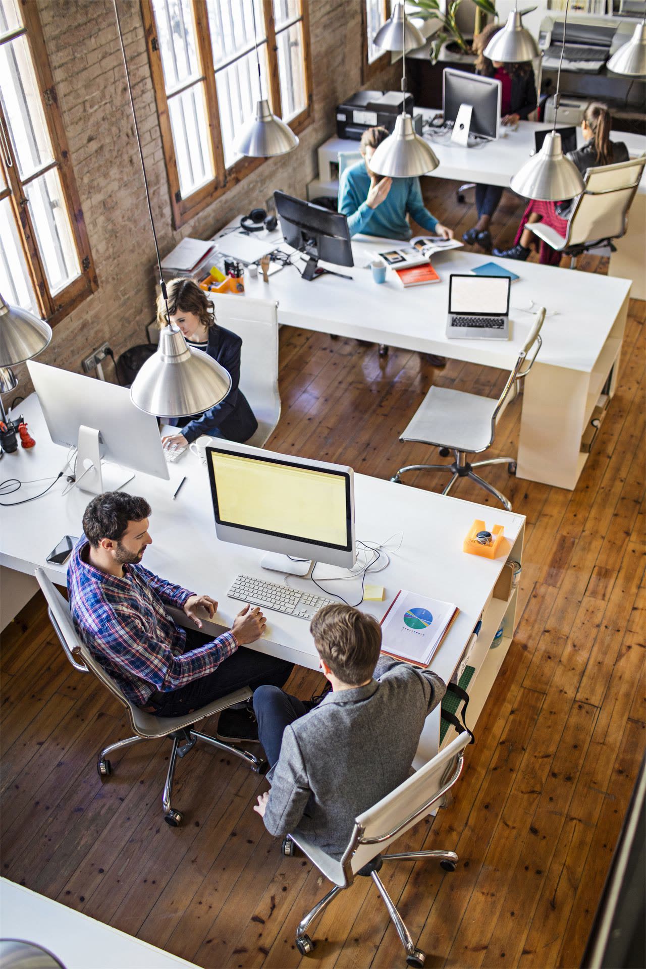 Open-plan office seen from above with people working at white desks, careers at Michelessi Marble