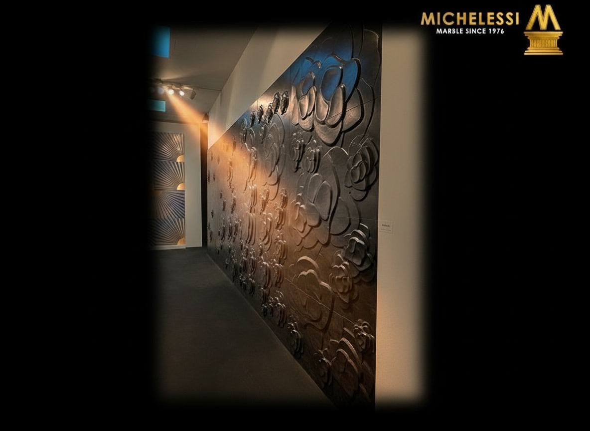 Corridoio con parete scura scolpita a camelie in rilievo, showroom lavorazione del marmo Michelessi