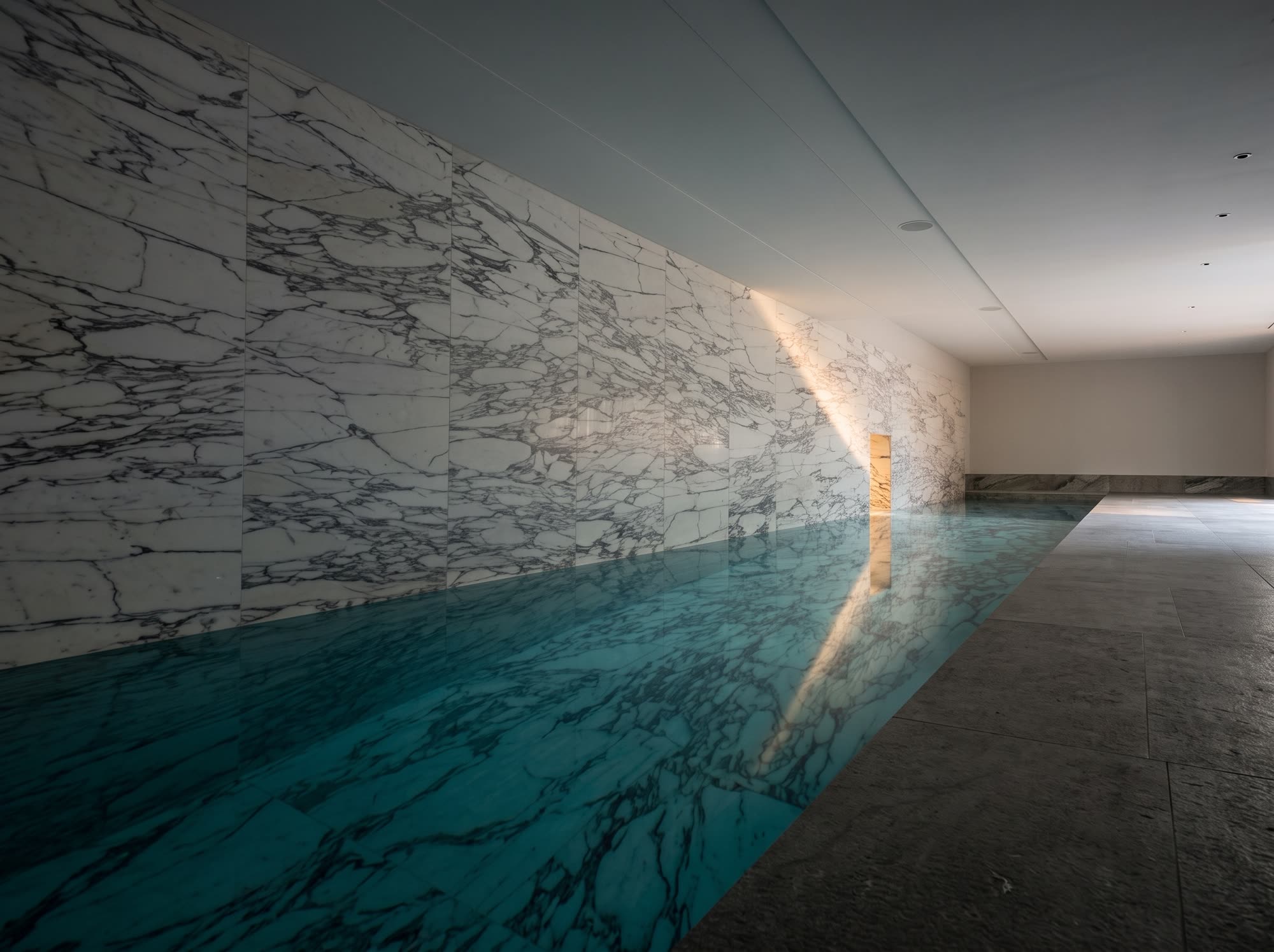 Piscina interna con pareti e fondo in lastre di marmo di Carrara venato, realizzazione Michelessi