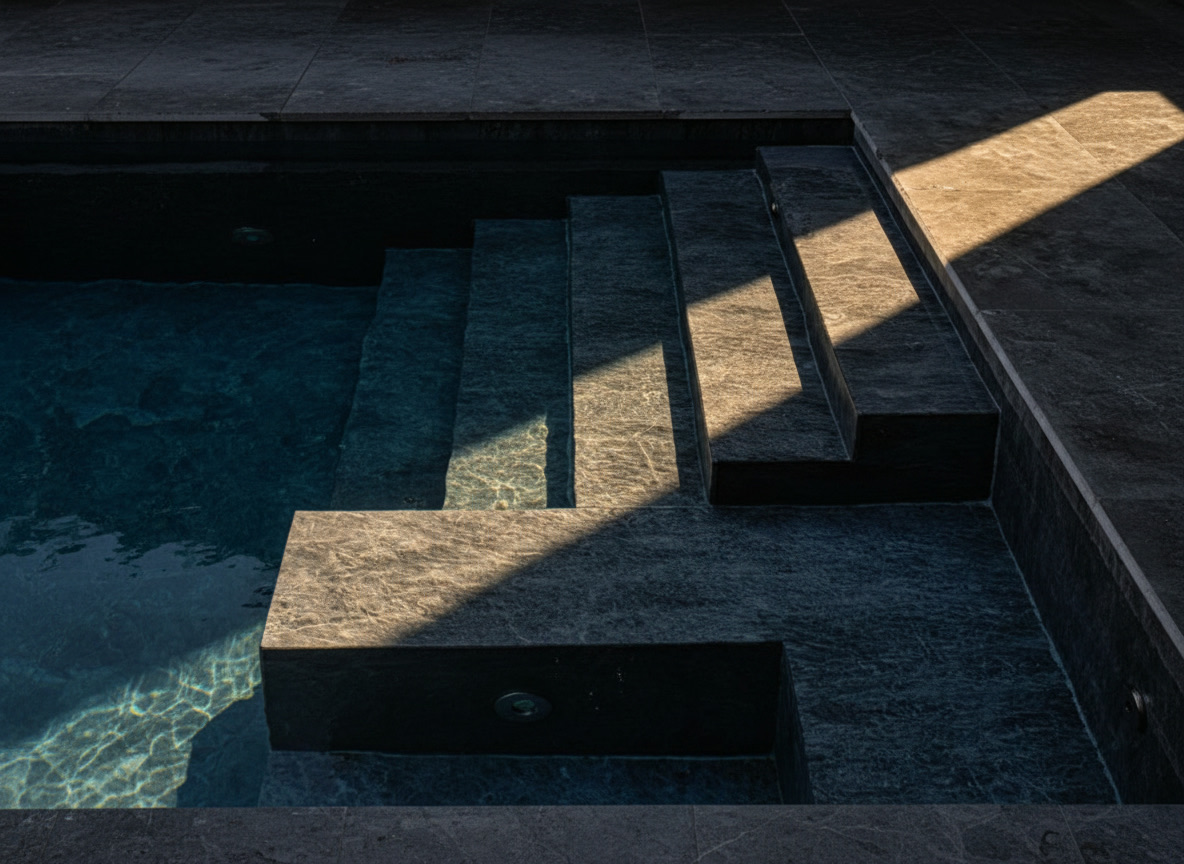 Rivestimento piscina in marmo grigio Kenya con scalinata e seduta immersa, lavorazione Michelessi