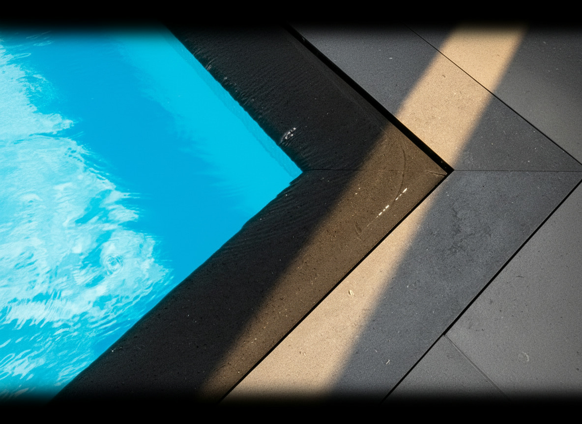 Bordo piscina in marmo nero a sfioro con fessura di raccolta e cornice rialzata in serpentino grigio, Michelessi