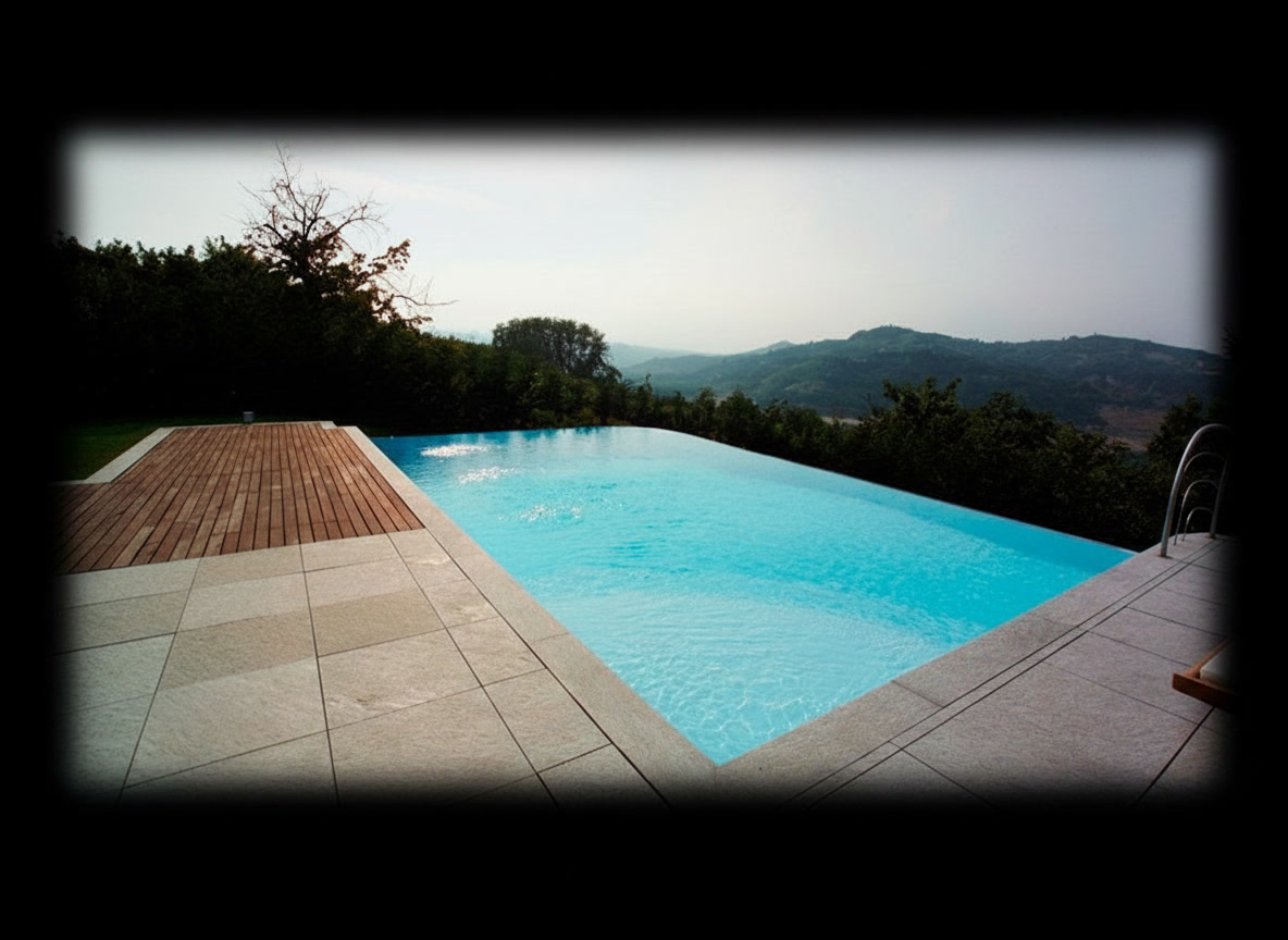 Piscina infinity rialzata con doppio bordo a cascata, pavimentazione in marmo e legno, colline al tramonto, Michelessi