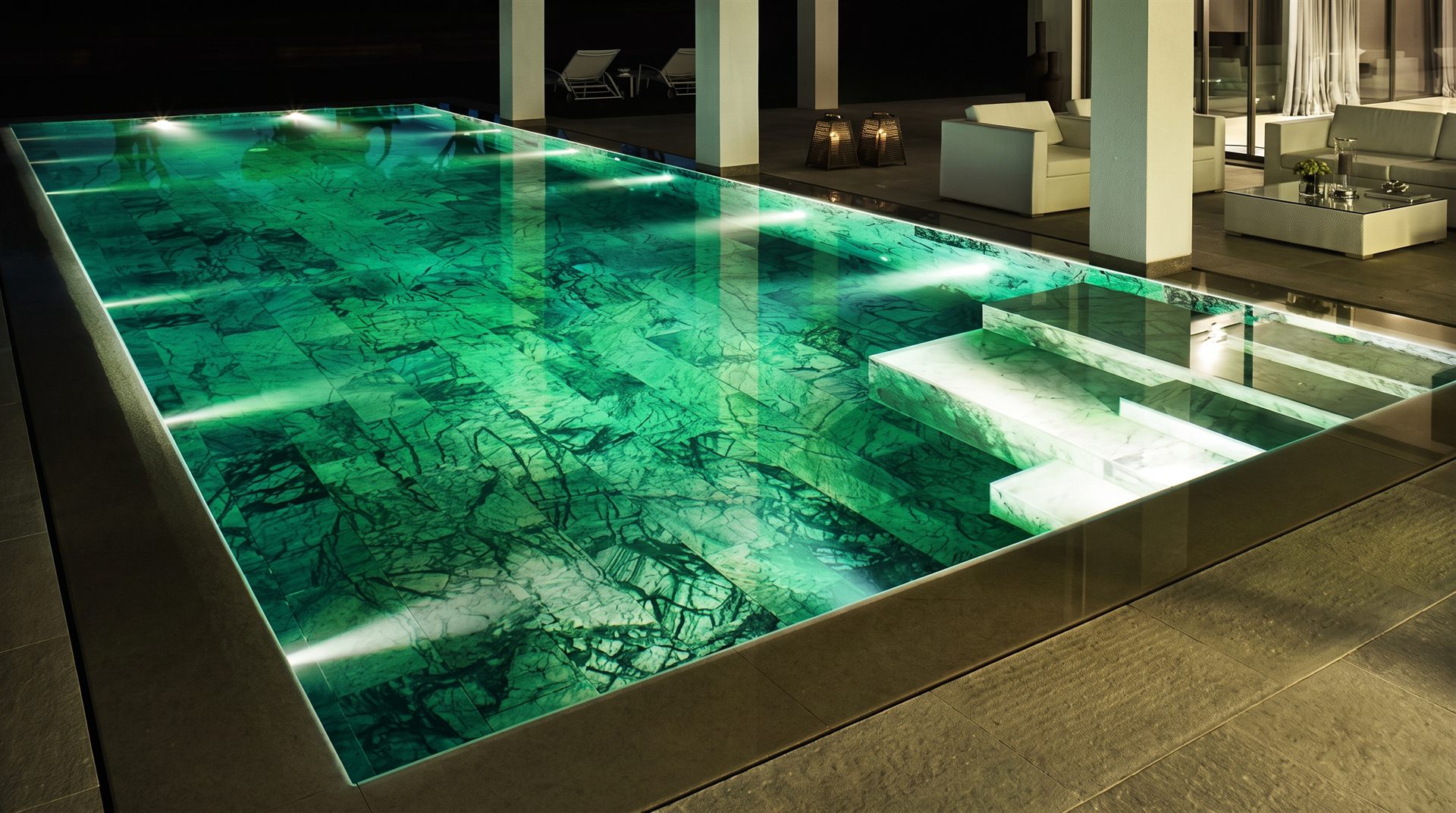 Visione di progetto: piscina notturna rivestita in marmo verde con gradini in pietra chiara e bordo scuro, progetti di lusso Michelessi