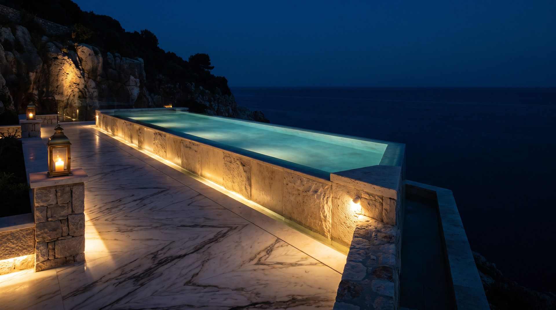 Visione di progetto: piscina a sfioro rivestita in travertino su una scogliera mediterranea al crepuscolo, con lanterne accese sul bordo in marmo
