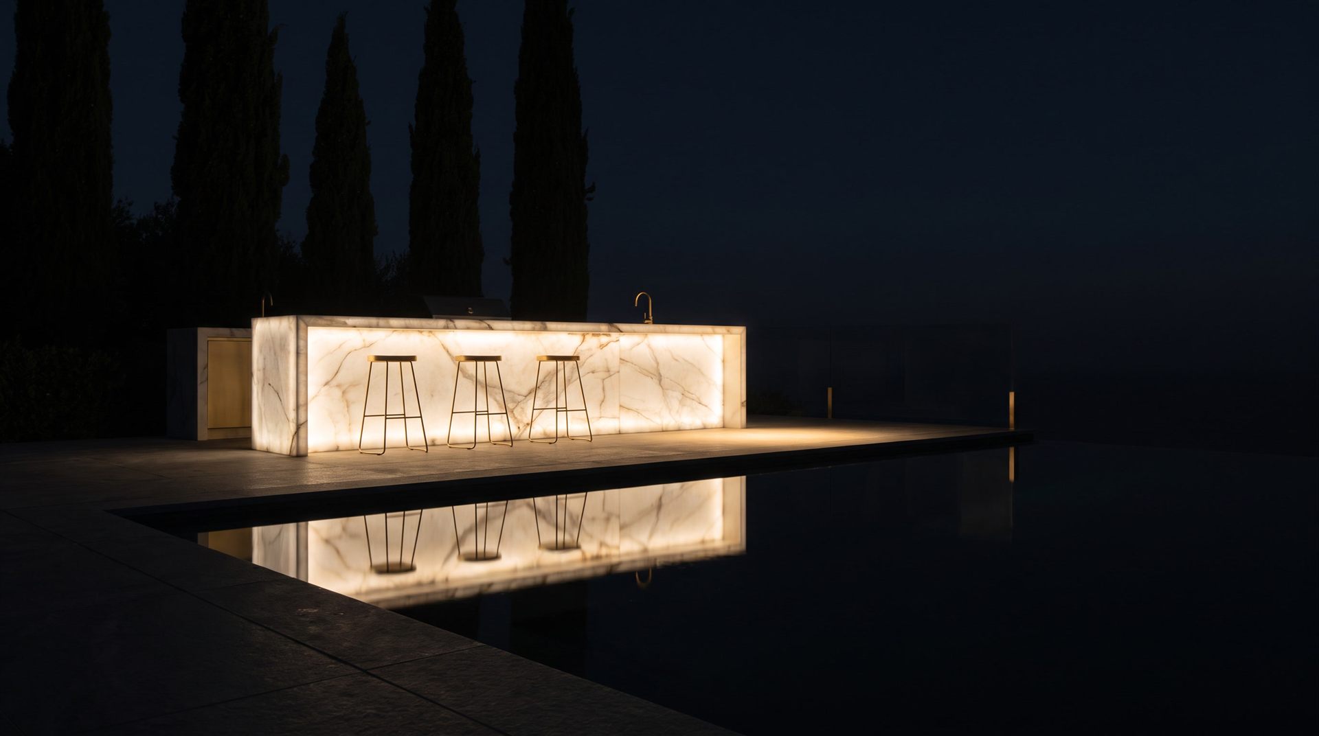 Visione Michelessi: banco bar in onice retroilluminato che brilla nella notte a bordo piscina, con sgabelli e cipressi, riflesso nell'acqua