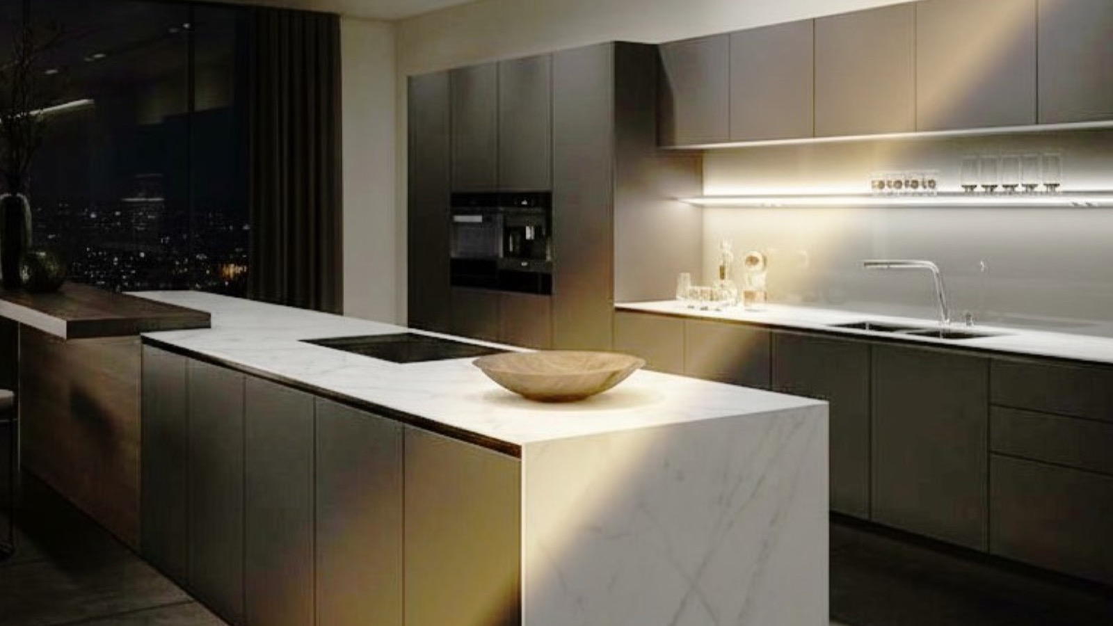 Dark lacquered wooden kitchen with veined travertine island with bar table and induction