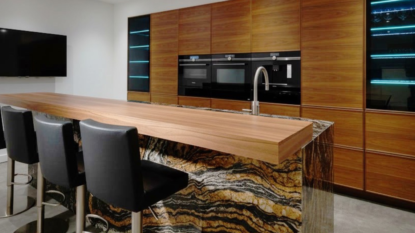 Central quartzite island with spectacular veining, wooden counter and black stools