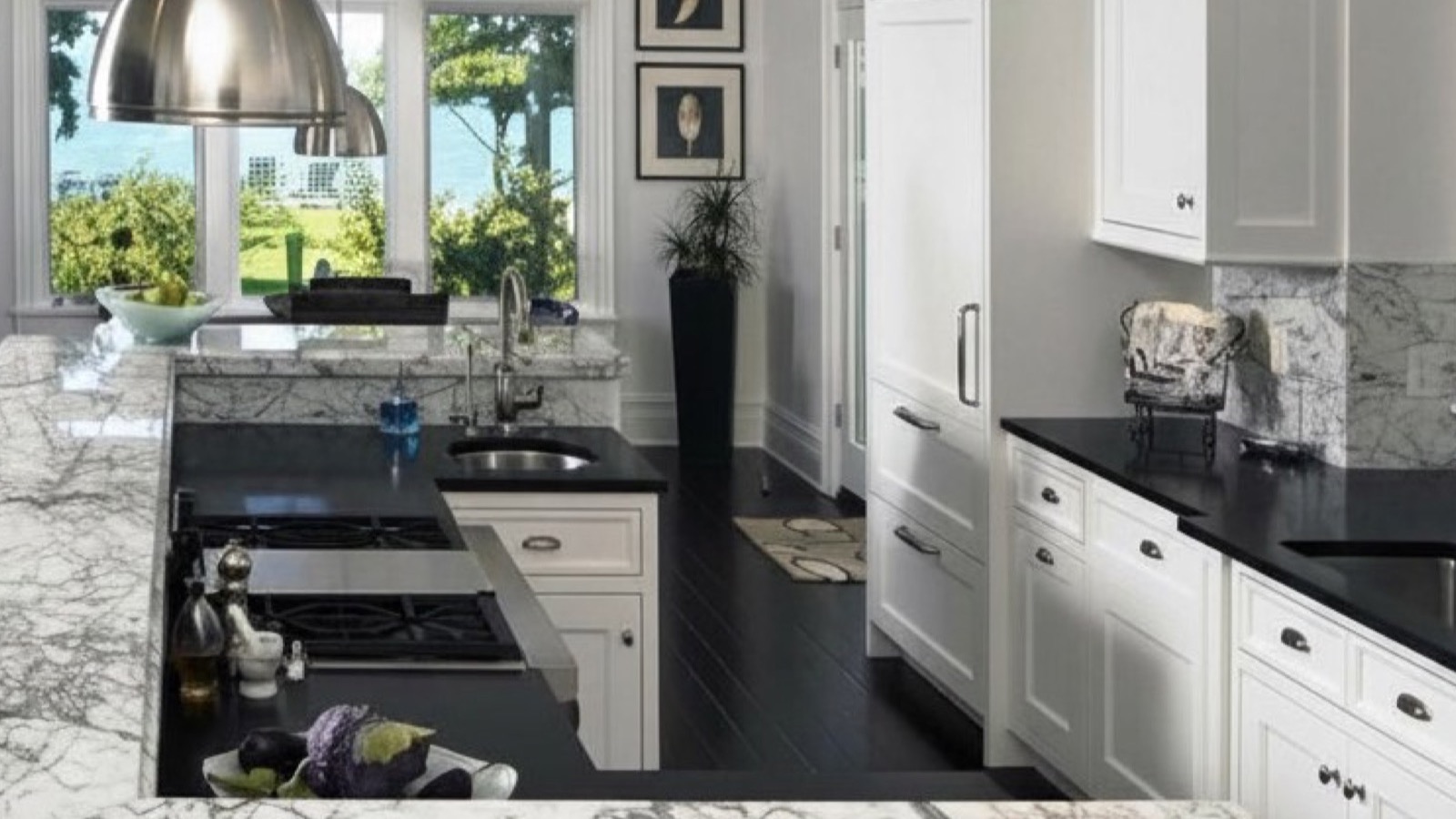 Elegant kitchen with accentuated-vein Carrara marble counters and black quartz tops