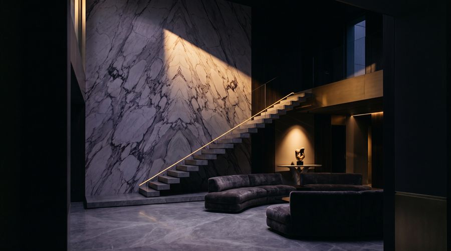 Design vision: double-height hall with a book-matched Paonazzo wall and a floating staircase, preview of the projects collection