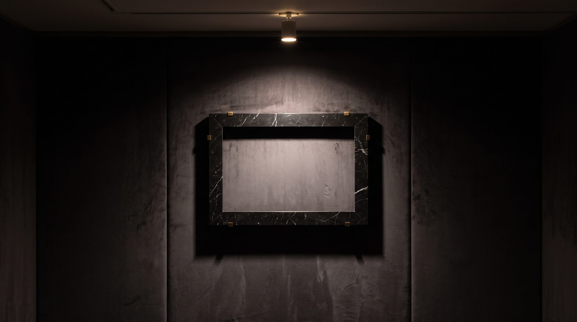 Visione di progetto: cornice moderna minimale in marmo Nero Marquinia con fermagli d'ottone, su una parete di velluto scuro sotto un solo faretto